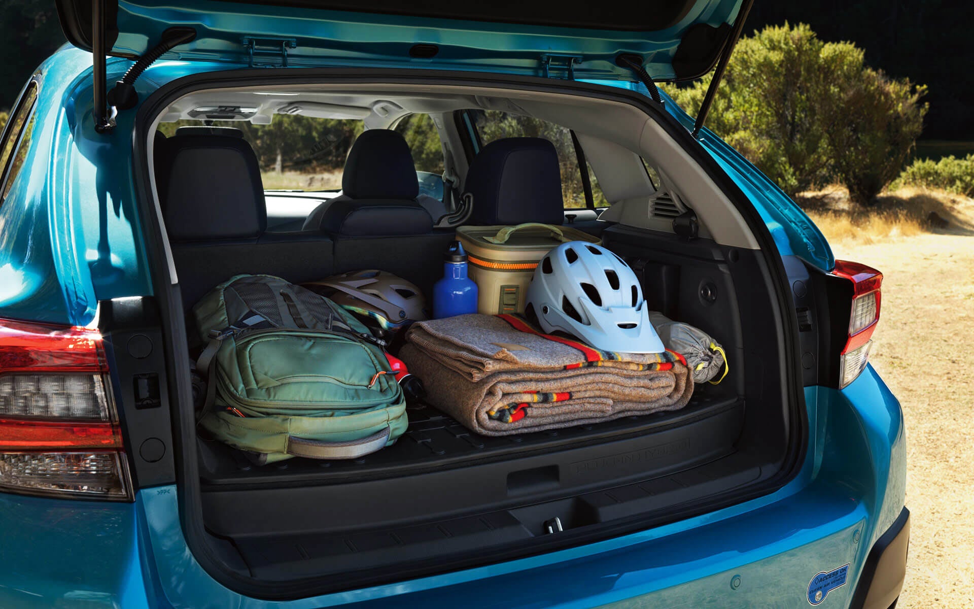 A backpack, blanket, and bike helmet in the rear cargo area of a Crosstrek Hybrid | Zappone Subaru Norwich in Norwich NY