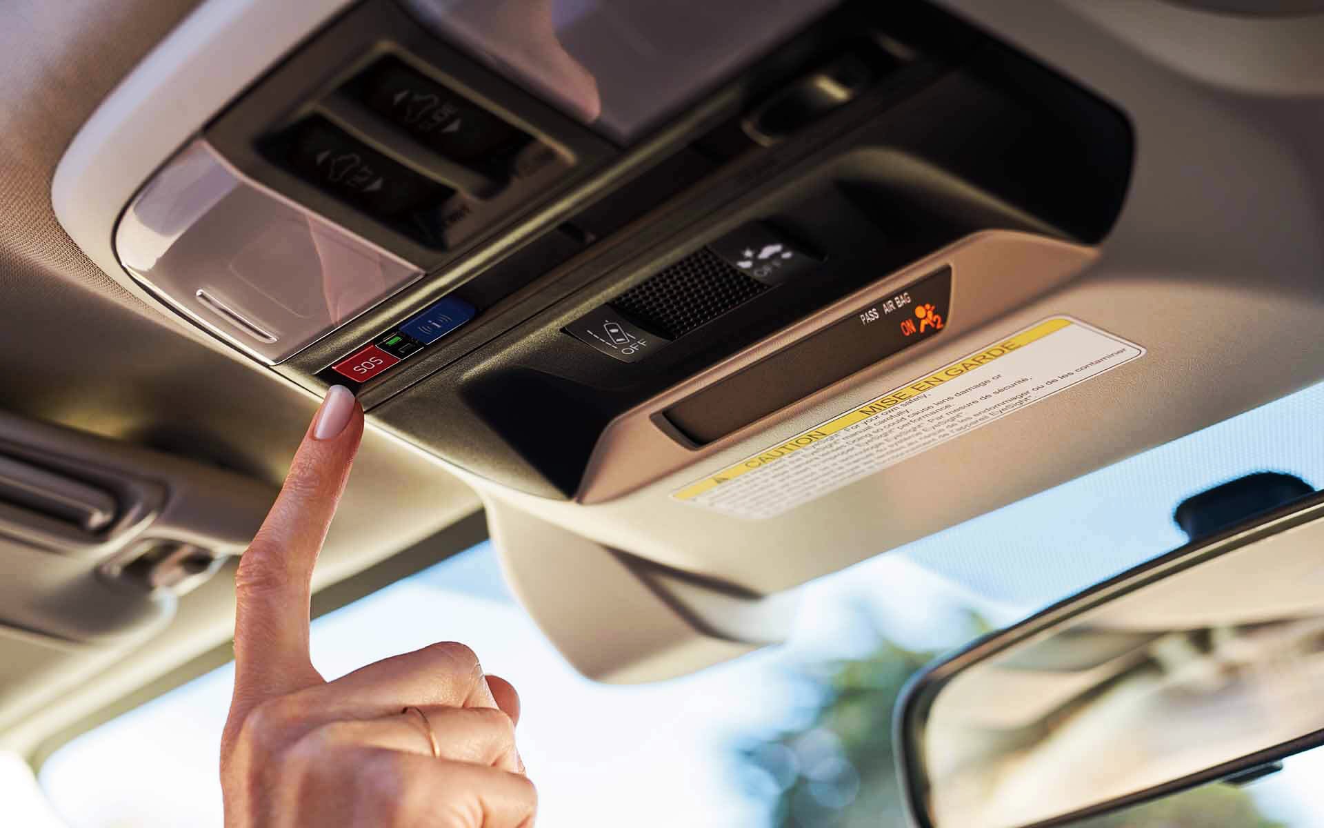 A finger pressing the Crosstrek Hybrid's SOS emergency assistance button | Zappone Subaru Norwich in Norwich NY