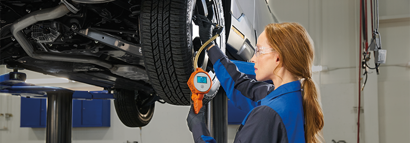 A Subaru technician checking tire pressure. | Zappone Subaru Norwich in Norwich NY